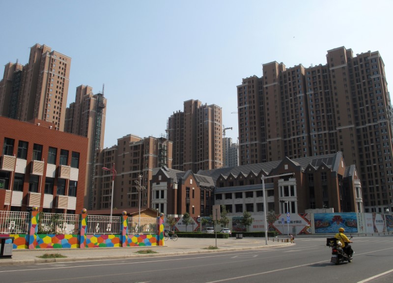 A food delivery man rides past residential buildings in Zhengzhou
