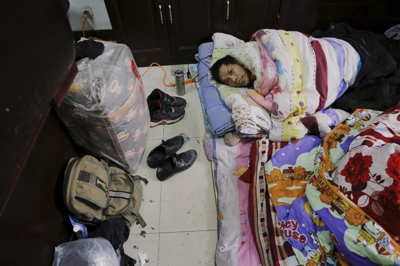 A migrant worker wakes up at the offices. Photo: Damir Sagolj, Reuters.