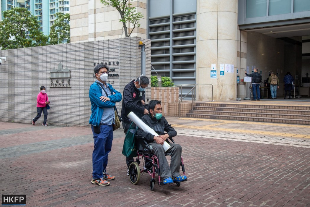 Claimant Hung Tat-fu (first from right) and Ng Wai-tung of the Society for Community Organization (middle) ourside the West Kowloon Law Courts Buidling on March 29, 2022. Photo: Kelly Ho/HKFP.