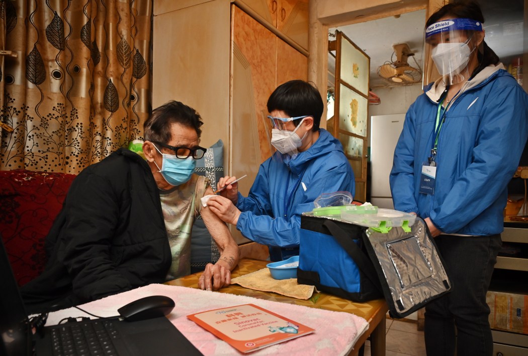 an elderly man receiving Covid-19 vaccination at home.