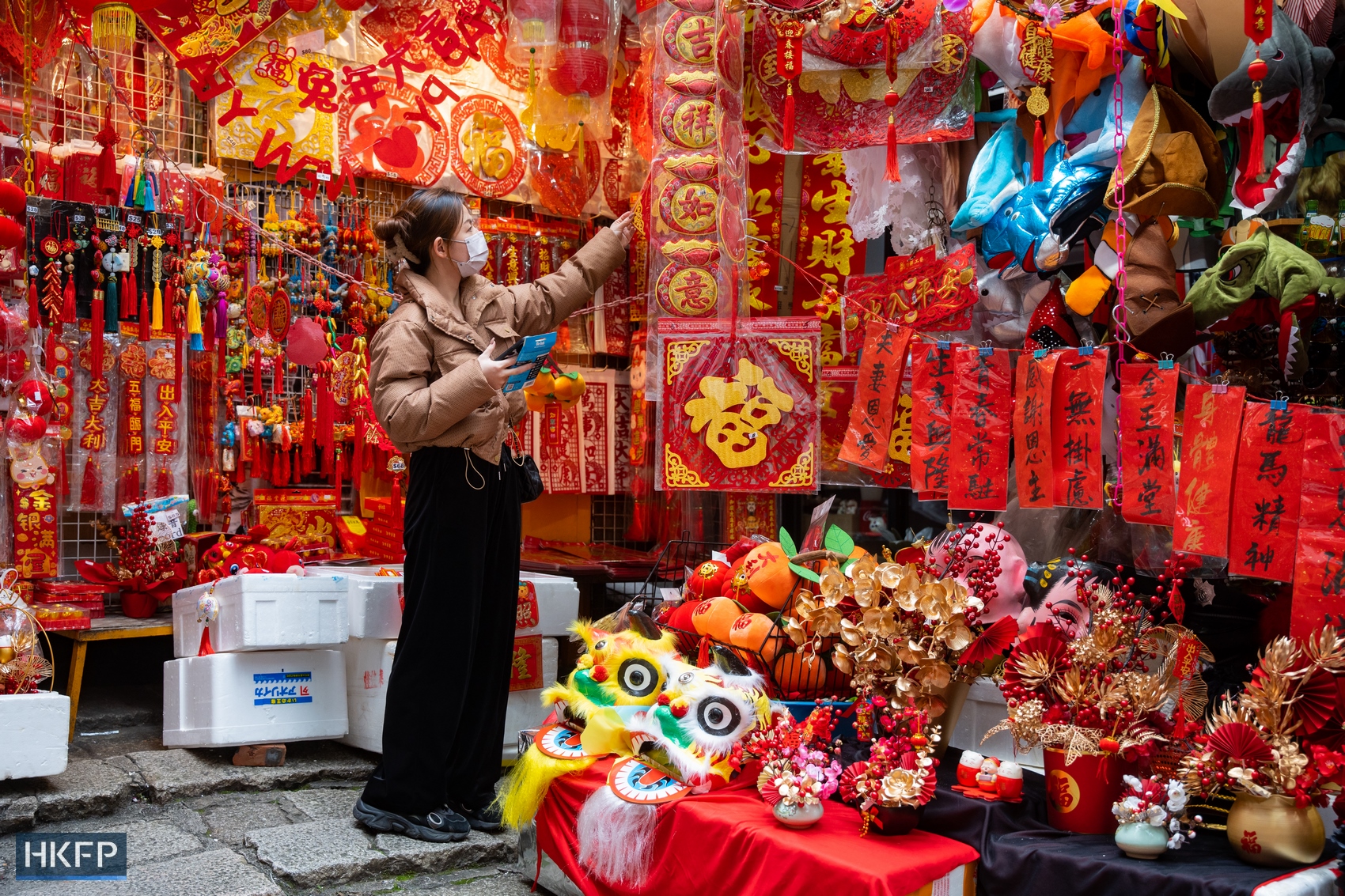 A woman looks at Lunar New Year decorations at a stall in Central, Hong Kong, in January 2023. Photo: Kyle Lam/HKFP.