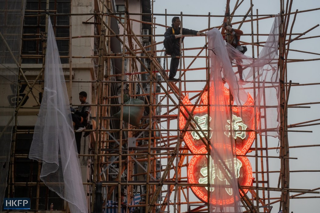 Workers putting a scaffolding over the neon shop sign of Nam Cheong Pawn Shop in Sham Shui Po on March 9, 2023