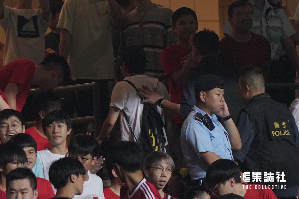 A man is taken away for investigation after showing a British colonial flag at the Hong Kong stadium.