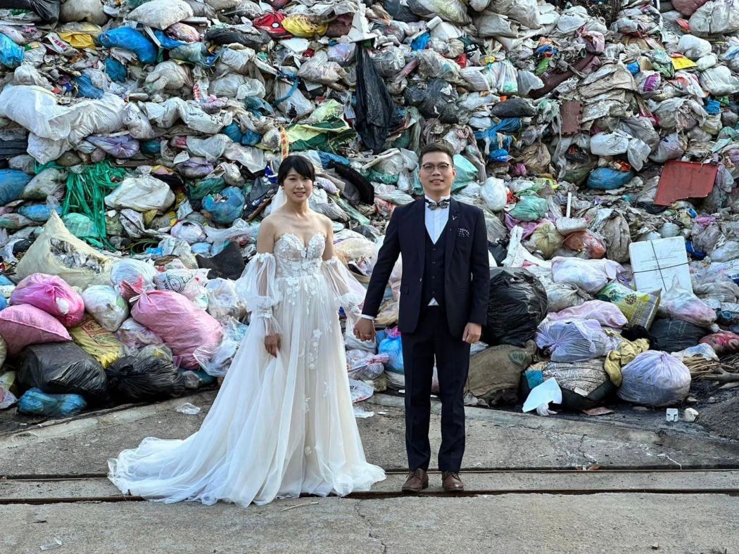 Iris Hsueh (left) and her fiance Ian Ciou posing for a photograph in front of a garbage hill in Puli Township, Nantou County on October 14, 2023. Photo: Iris Hsueh/Facebook.