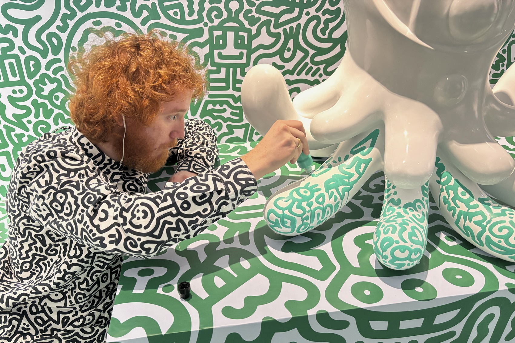 British artist Sam Cox, better known as Mr. Doodle, posing for a picture with his piece "The Doodles Leave Earth" at Pearl Lam Galleries in Hong Kong on November 16, 2023, Photo: Dene Chen/AFP.