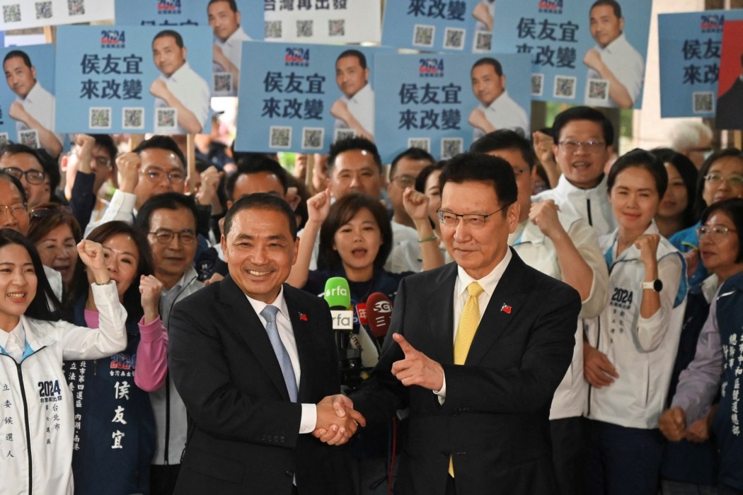Hou Yu-ih (left), Taiwanese presidential candidate from the main opposition party Kuomintang (KMT), shakes hands with his KMT running mate Jaw Shaw-kong after they registered for the upcoming 2024 presidential elections at the Central Elections Commission in Taipei on November 24, 2023. Photo: Sam Yeh/AFP.