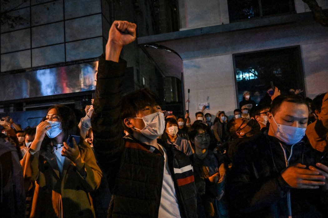 People sing slogans while gathering on a street in Shanghai on November 27, 2022, where protests against China's zero-Covid policy took place the night before following a deadly fire in Urumqi, the capital of the Xinjiang region. Photo: Hector Retamal/AFP.