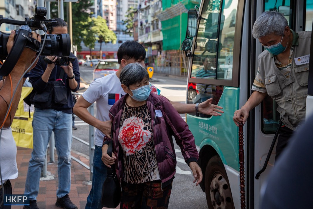 Elderly residents get off a bus outside a polling station for Hong Kong's "patriots only" District Council election, on December 10, 2023. Photo: Kelly Ho/HKFP.