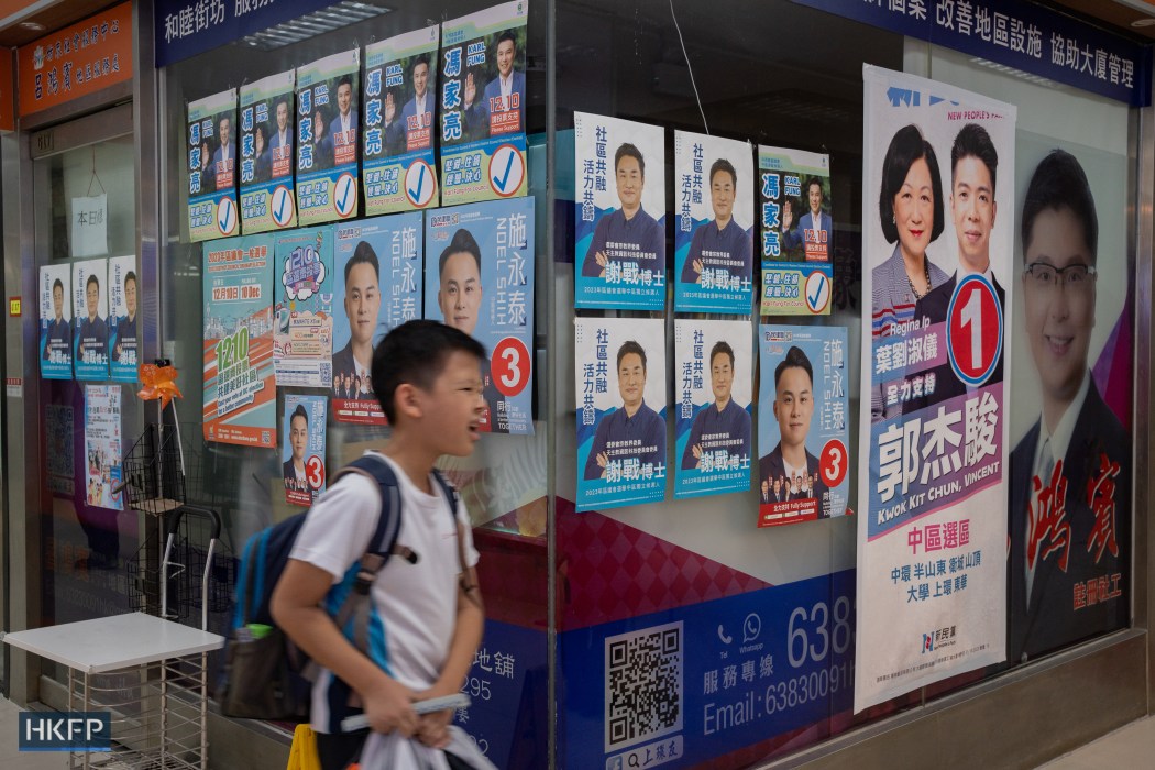 Poster of 2023 Hong Kong District Council Election candidates displayed in a shopping mall in Sheung Wan. Photo: Kyle Lam/HKFP