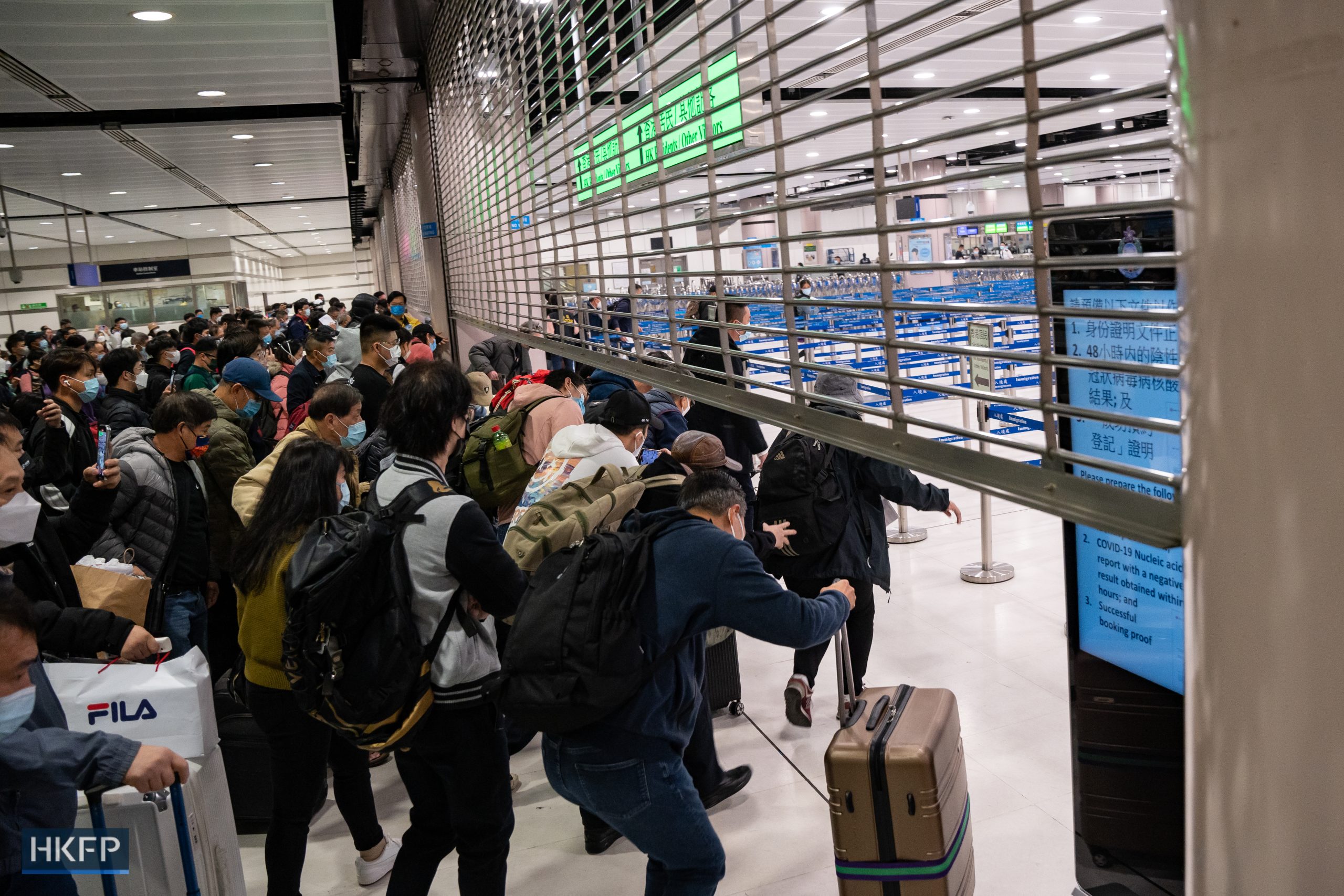 Travellers rush through a border control point at Lok Ma Chau on January 8, 2023, when Hong Kong’s border with mainland China partially reopened after Covid-19, Photo: Kyle Lam/HKFP.