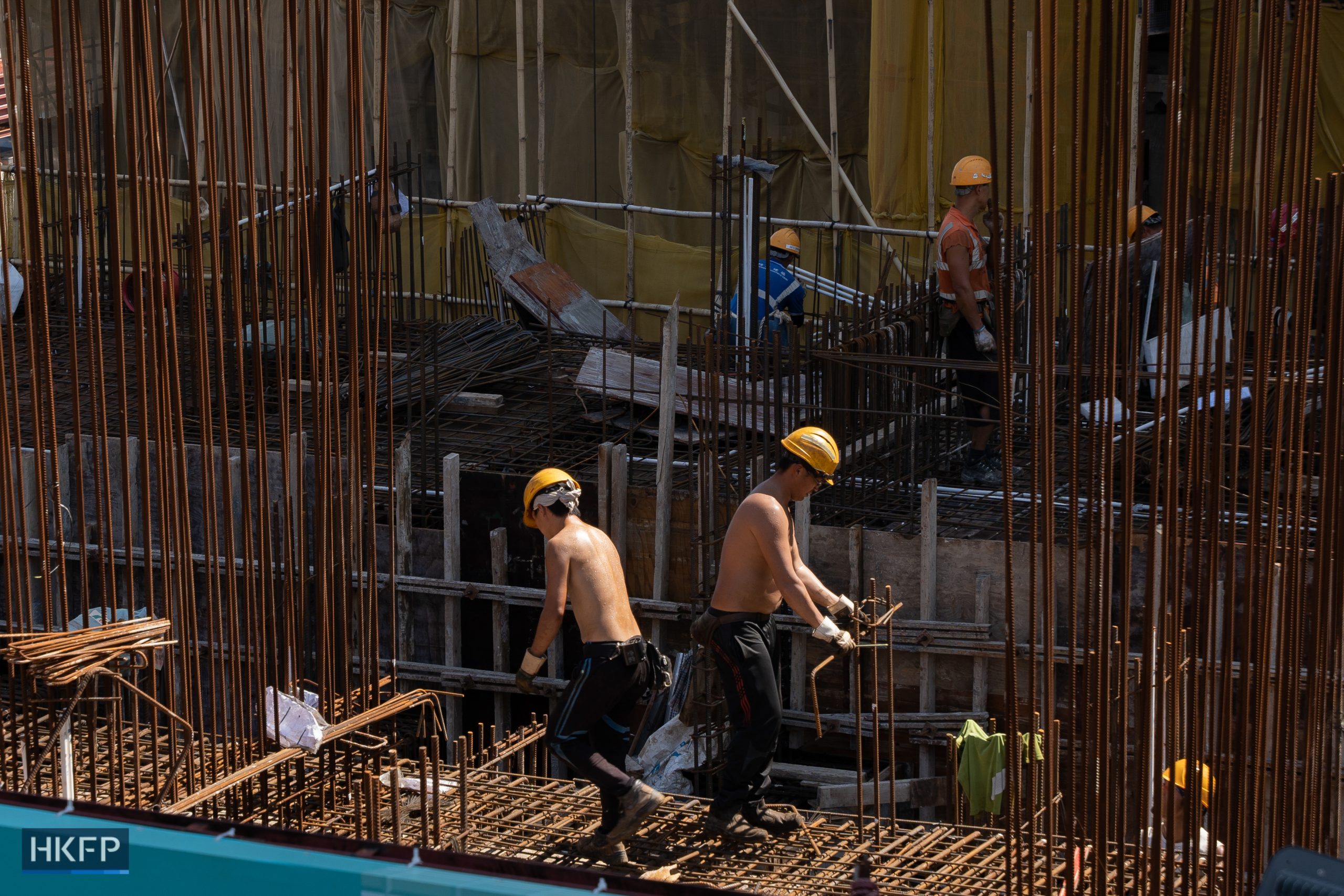 Construction workers work in hot weather in Hong Kong on August 16, 2023. Hong Kong introduced a heatstroke warning system for outdoor workers, the city has sweated through its hottest summer since records began in 1884, according to the Hong Kong Observatory (HKO). Photo: Kyle Lam/HKFP.