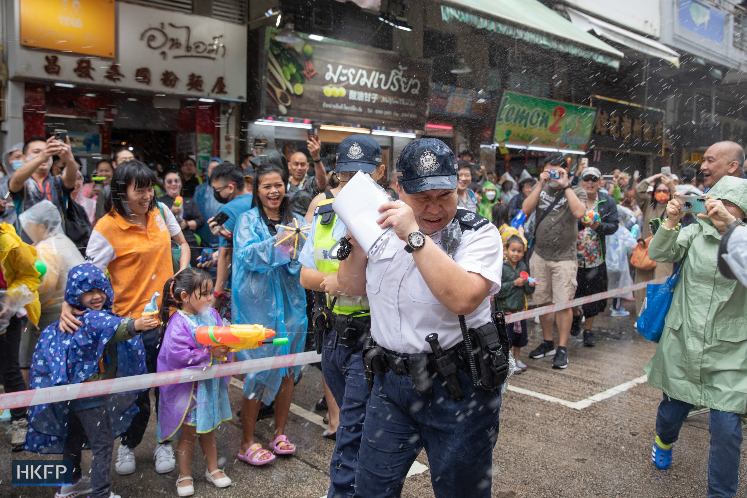 Citizens spray water on police officers during Songkran Festival in Kowloon City on April 9, 2023. Four days later, 2 men were arrested and accused of “assaulting police officers”. Photo: Kyle Lam/HKFP.