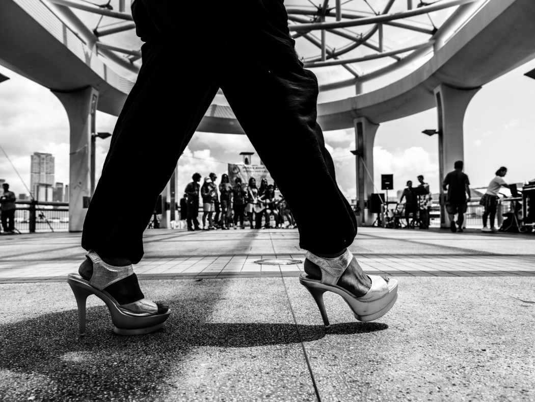 A migrant domestic worker walking with high heels in Hong Kong, September 10, 2017. Photo: Xyza Cruz Bacani. 