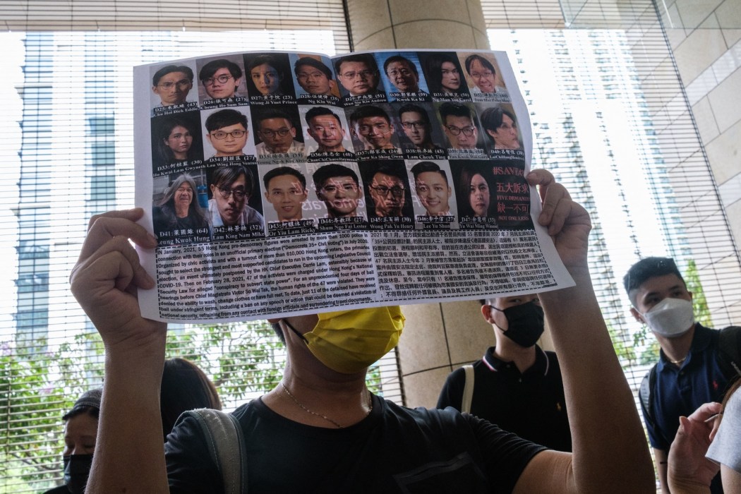 A supporter holds a poster showing some of the 47 pro-democracy activists on trial at the West Kowloon Court in Hong Kong on July 8, 2021.