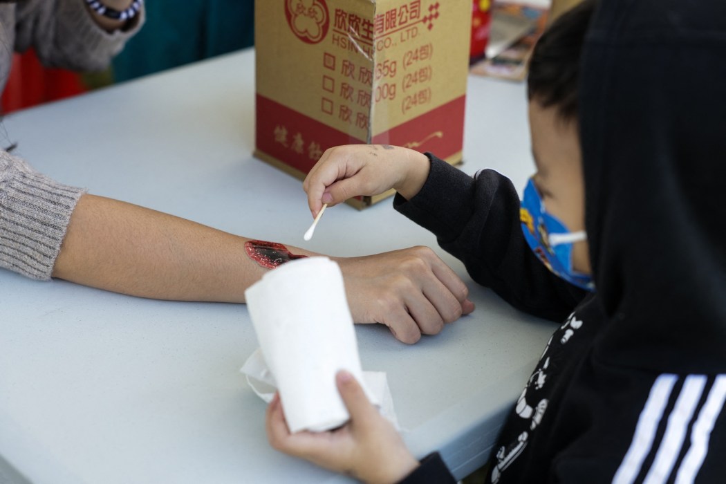 Children practice to put bandages on their parents during an event held by Taiwanese civil defense organization Kuma Academy, in New Taipei City on November 18, 2023. Photo: I-Hwa Cheng/AFP.