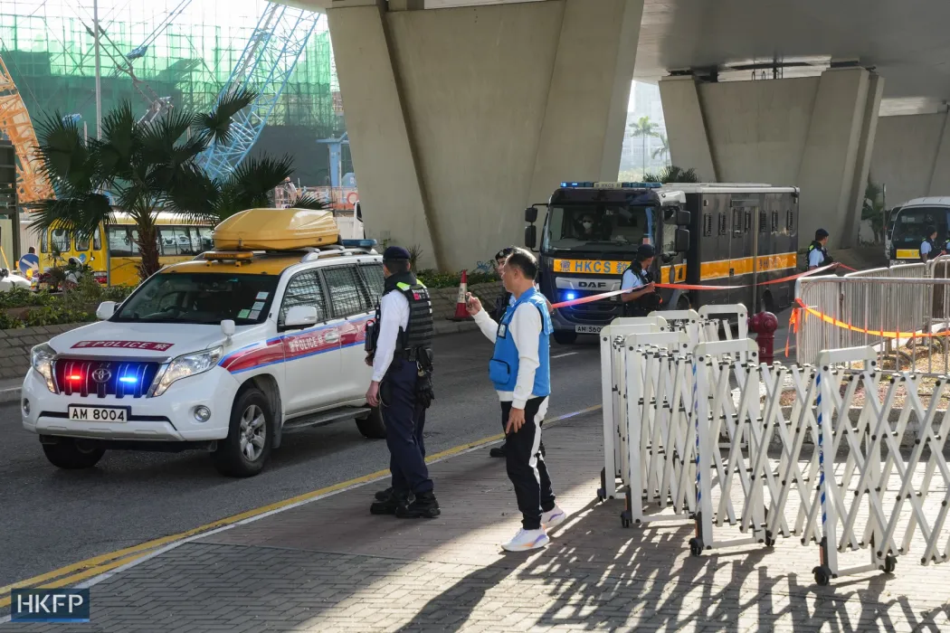 A Correctional Services Department vehicle and a police vehicle outside the West Kowloon Law Courts Building on February 2, 2024. Photo: Kyle Lam/HKFP.