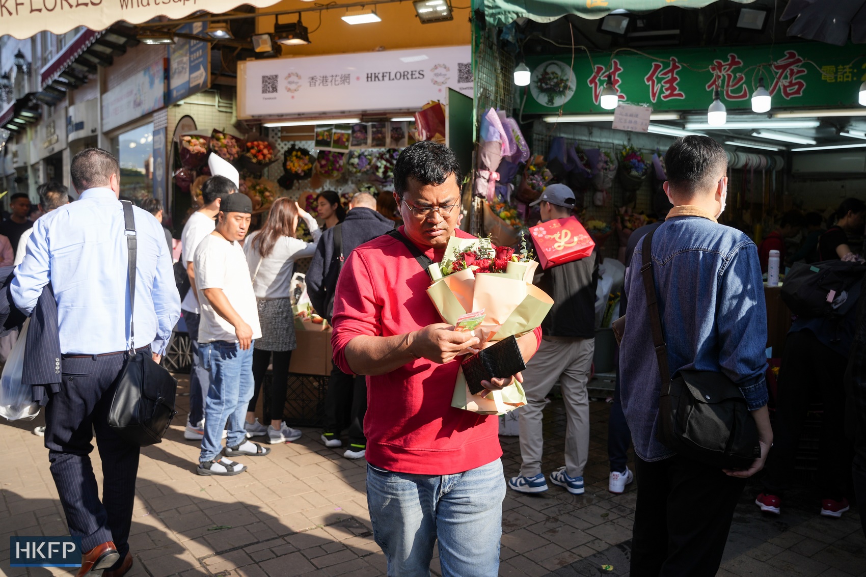 A man holds a bouquet at the Flower Market in Mong Kok on February 14, 2024. Photo: Kyle Lam/HKFP.