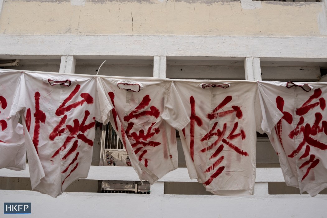 The Chinese character for "tragic" repeats itself across a makeshift banner at Tai Hang Sai Estate. Photo: Kyle Lam/HKFP.
