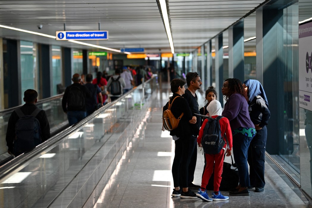 A family are asked questions about forced marriage by officials and a member of UK Border Force after landing from Bangalore in India, in Terminal 2 at Heathrow Airport in London on July 16, 2019, part of Operation Limelight, a national multi-agency safeguarding operation at the UK border that focuses on harmful practices. In collaboration with Border Force, specialist officers from the Met's Continuous Policing Improvement Command will be carrying out preventative and detection work in relation to inbound flights that have travelled from or via 'countries of prevalence' for forced marriage, female genital mutilation (FGM) and honour based abuse and breast ironing. Photo: Daniel Leal/AFP.