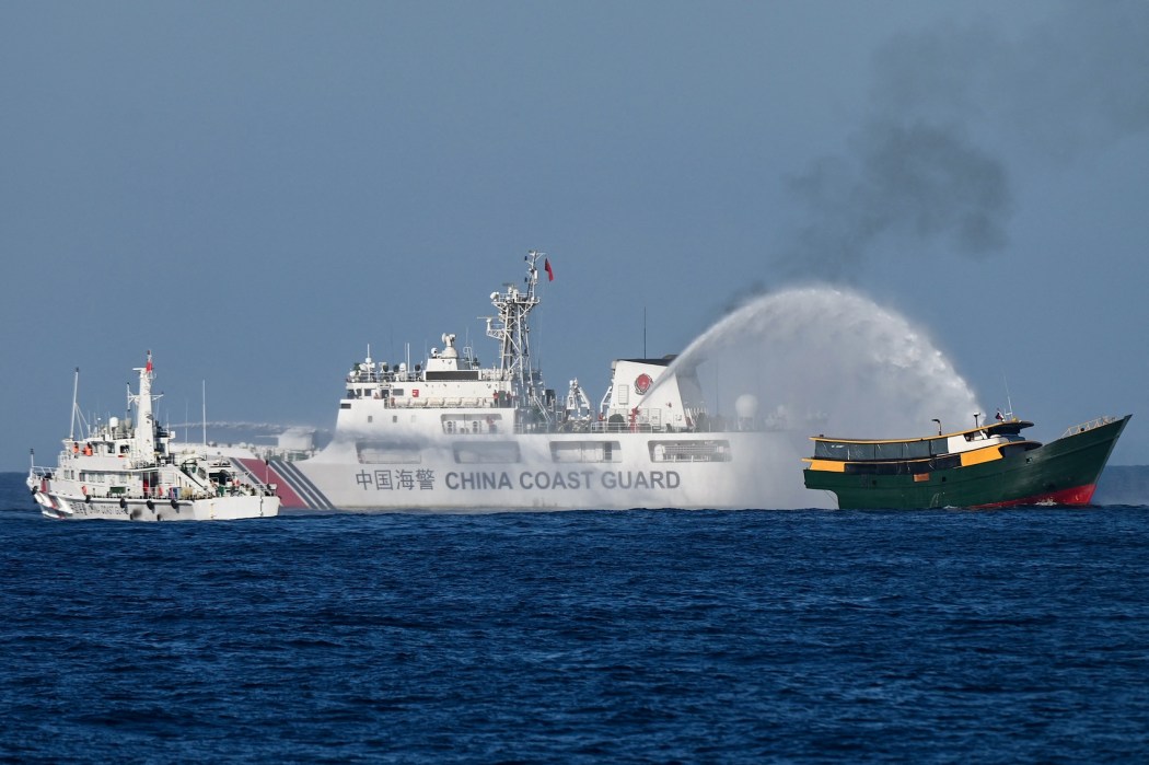 China Coast Guard vessels deploy water cannons at the Philippine military chartered Unaizah May 4 (right) during its supply mission to Second Thomas Shoal in the disputed South China Sea on March 5, 2024. 