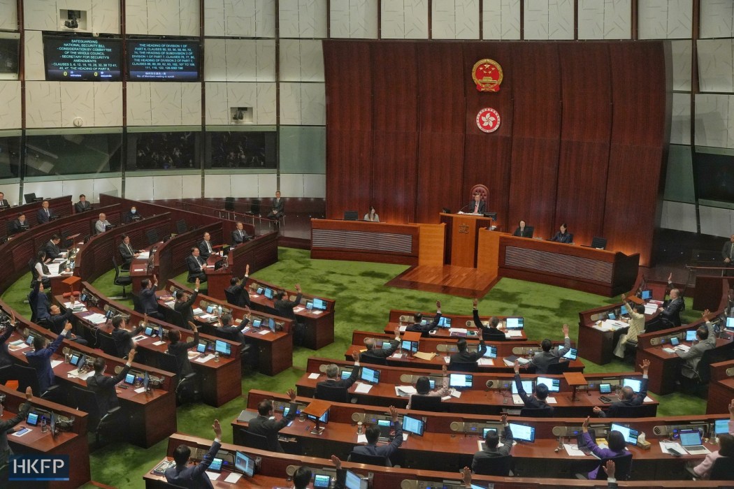 Hong Kong lawmakers raise their hands in a meeting as they resume the debate on a proposed domestic security law required under Article 23 of the Basic Law on March 19, 2024.