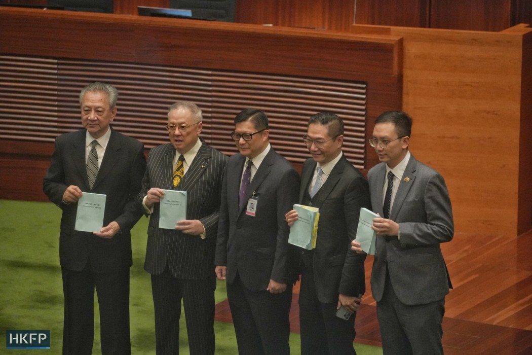 Hong Kong Secretary for Security Chris Tang (middle) takes a photo with lawmakers on March 19, 2024 as legislators resume the debate on a proposed domestic security law required under Article 23 of the Basic Law. Photo: Kyle Lam/HKFP.