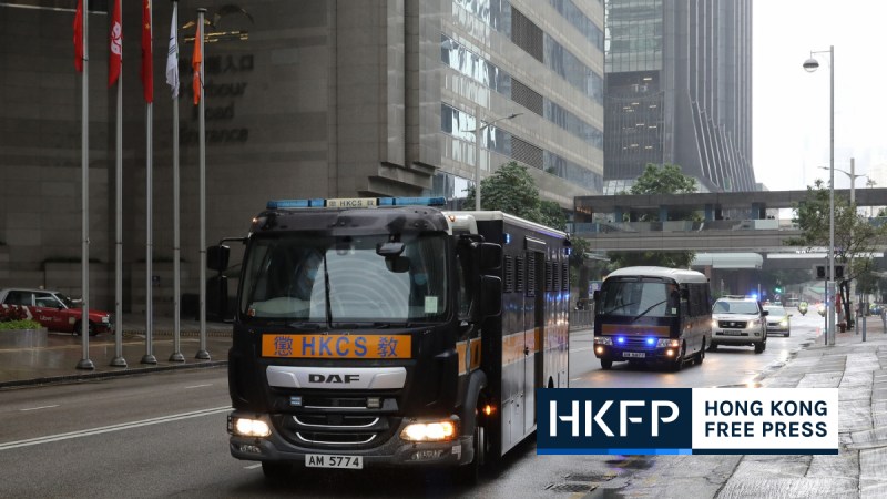 Two prison vans followed by police cars arriving at the District Court on November 24, 2022. File photo: Kyle Lam/HKFP.