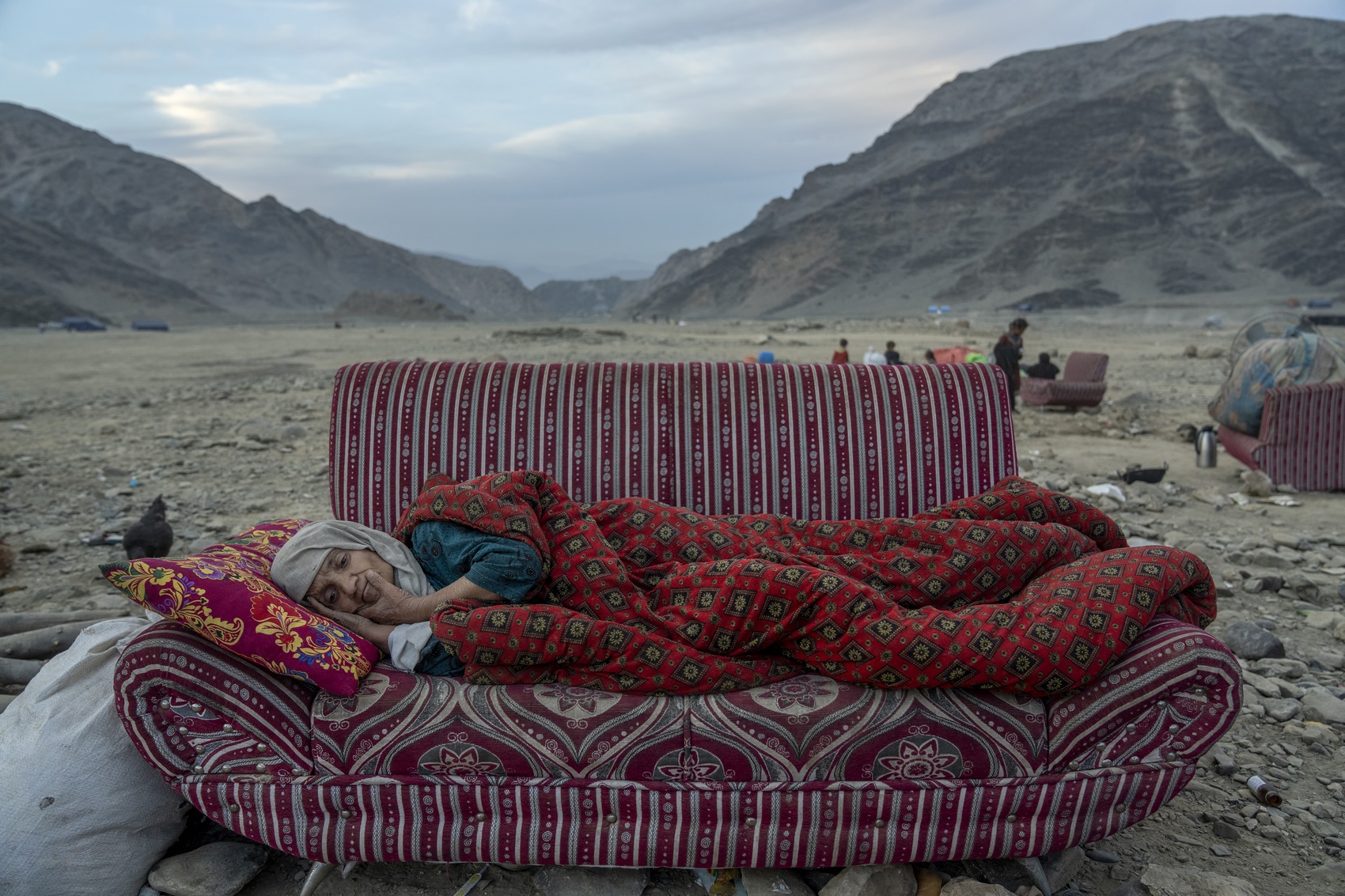 An Afghan refugee rests in the desert next to a camp near the Torkham Pakistan-Afghanistan border, in Torkham, Afghanistan, on Novevember 17, 2023. Photo: Ebrahim Noroozi/AP.