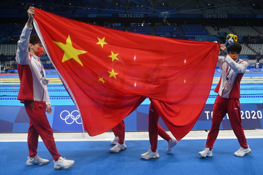 Silver medallists China's Xu Jiayu, China's Yan Zibei, China's Zhang Yufei and China's Yang Junxuan celebrate with a flag after the final of the mixed 4x100m medley relay swimming event during the Tokyo 2020 Olympic Games at the Tokyo Aquatics Centre in Tokyo on July 31, 2021.