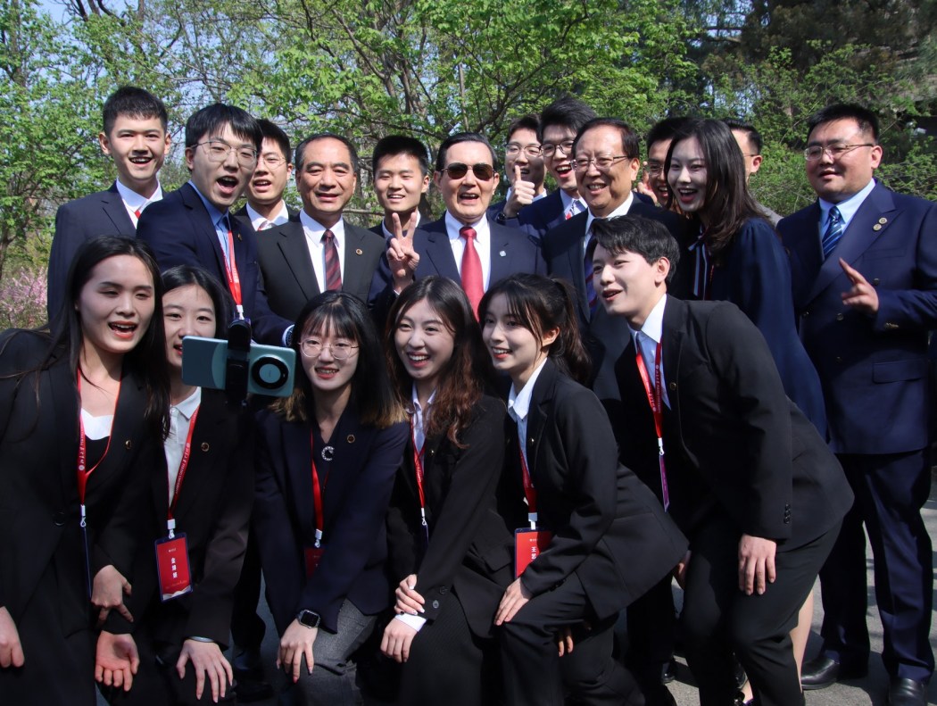Former Taiwanese president Ma Ying-jeou (centre) posese for photographs with Peking University students in Beijing on April 9, 2024.