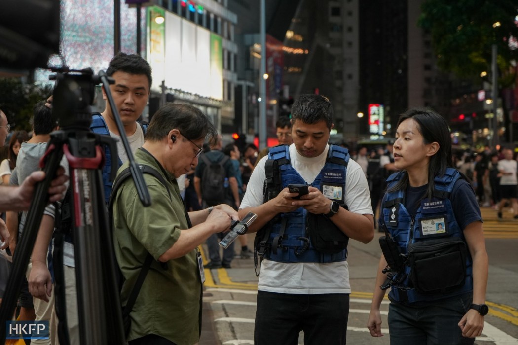 Police media liaison officers in Causeway Bay, Hong Kong, on June 4, 2024, the 35th anniversary of the 1989 Tiananmen crackdown. Photo: Kelly Ho/HKFP.